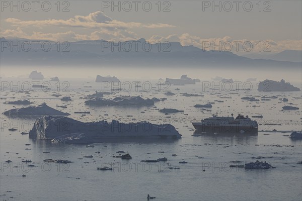 Hurtigruten ship sails through icebergs and ice floes, summer, midnight sun, Jakobshavn glacier and