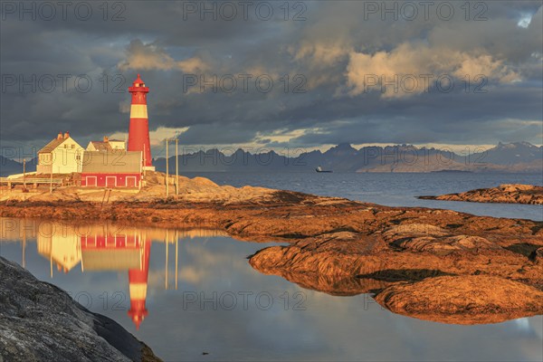Lighthouse reflected in water, morning light, clouds, mountains, coast, Tranoy, Ofoten, Norway,