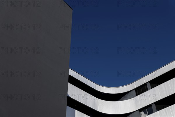Beautiful Modern Concrete Design Building with Metal Balcony Against Blue Clear Sky in Switzerland
