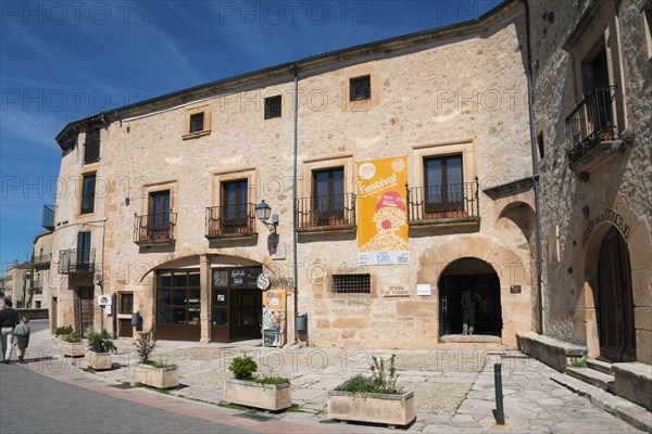 Stone building with information posters and old windows on a sunny street, former prison, museum,