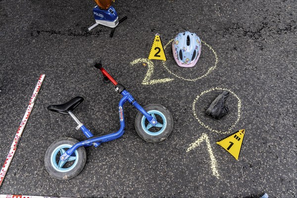 Markings at an accident scene with a balance bike for children, helmet, reenacted accident