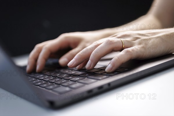 Hands typing on a laptop keyboard in Berlin, 09/08/2024