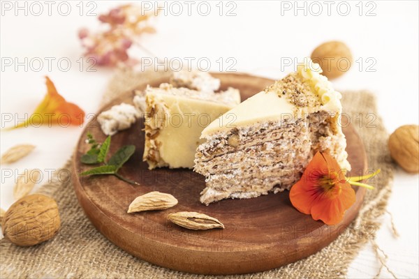 Walnut and almond cake on white wooden background and linen textile. side view, close up, selective