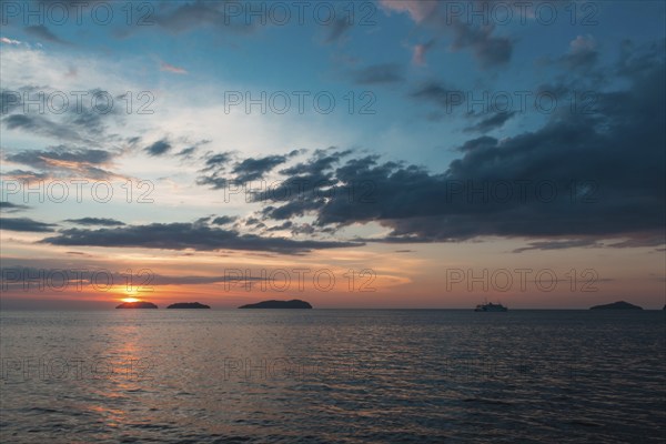 Beautiful purple sunset on the sea with small islands on the horizon
