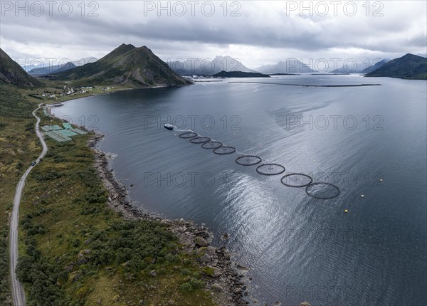 Aerial view of a salmon farm, rainy weather, grey sky, village Myre in the back, Vesteralen