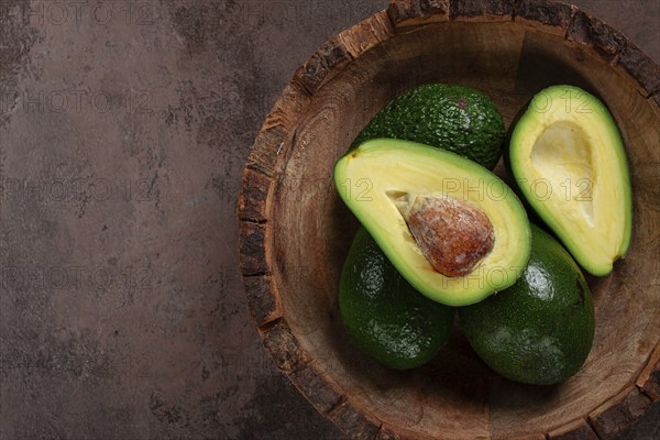 Fresh, sliced avocado, in a wooden plate, top view, food background, concept, food styling