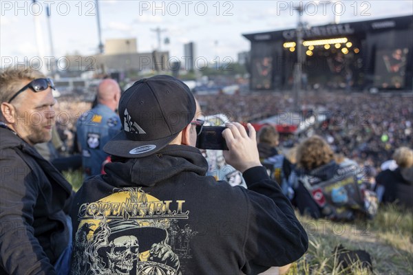 Copenhagen, Denmark - 19 June 2024: Festivalgoers in front of the logo at the Copenhell Metal