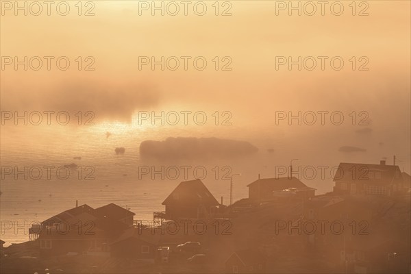 Inuit settlement in front of icebergs in the fog, midnight sun, summer, Ilulissat, Ilulissat