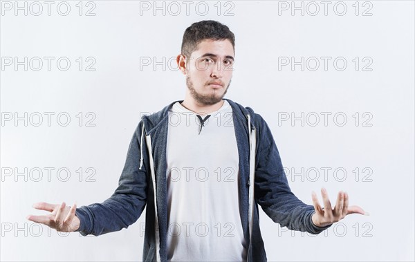 Puzzled person spreading hands isolated. Clueless young man with open arms