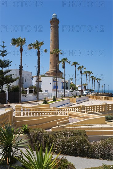 Promenade with palm trees and lighthouse on a sunny day, Faro de Chipiona, Chipiona, Cádiz