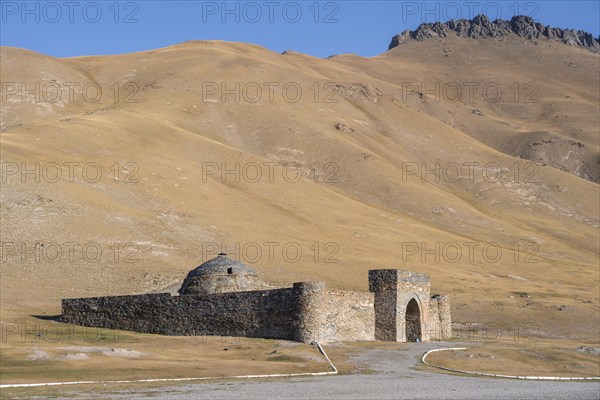 Historic caravanserai Tash Rabat from the 15th century, with yellow hills, Atbashy district in the