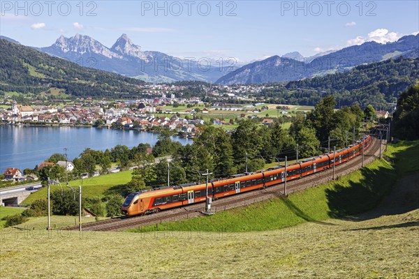 Railway passenger train of the type Stadler Flirt of the Südostbahn on the mountain Großer Mythen