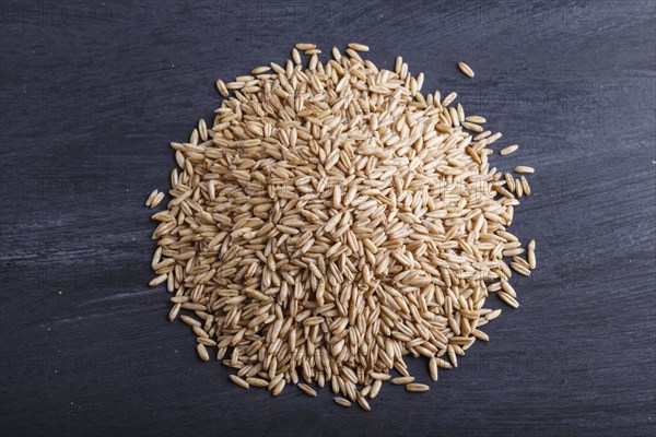 Heap of oats grains isolated on black background. close up, top view