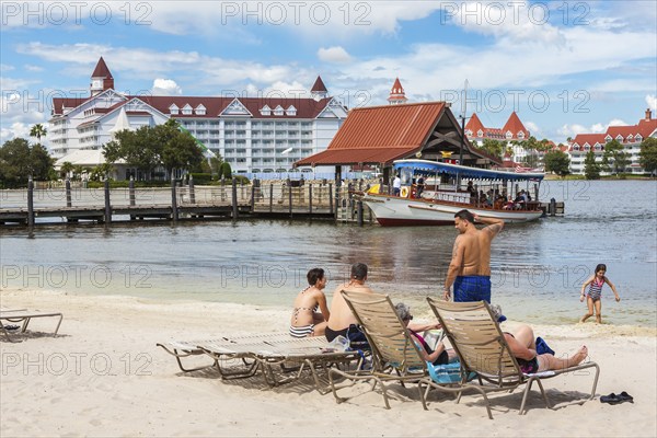 Disney's Polynesian Resort guests enjoy the beach overlooking the Grand Floridian Resort in Walt