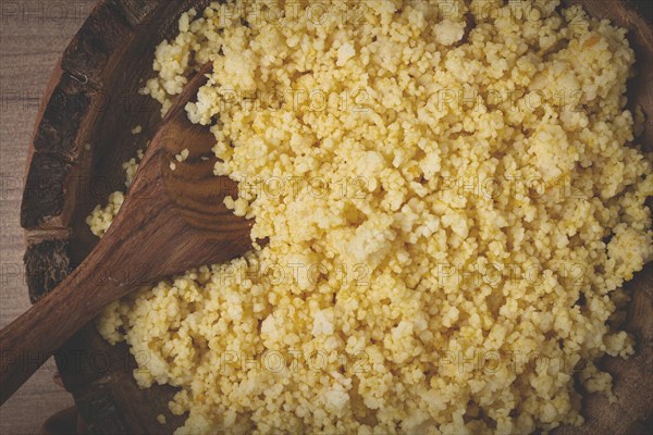 Cooked couscous, in a wooden bowl, top view, no people