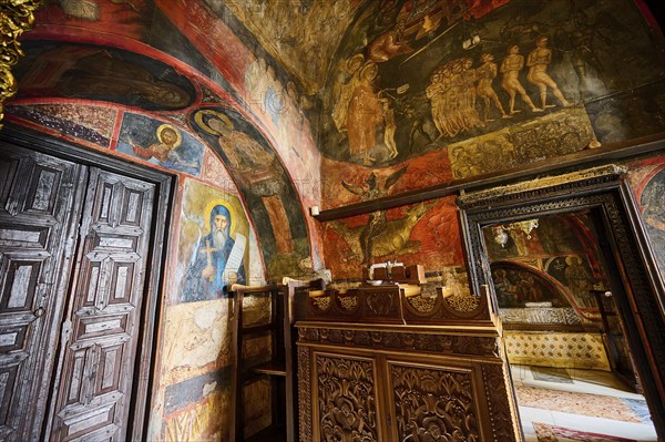 The scene shows an Orthodox icon and wall painting in a room with wooden doors and detailed