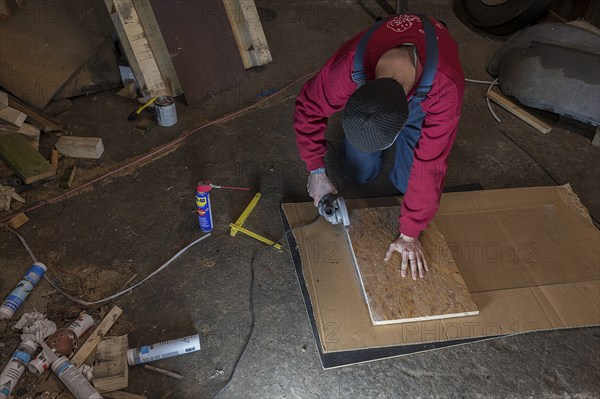 Young man working with an angle grinder in his workshop, Mecklenburg-Western Pomerania, Germany,