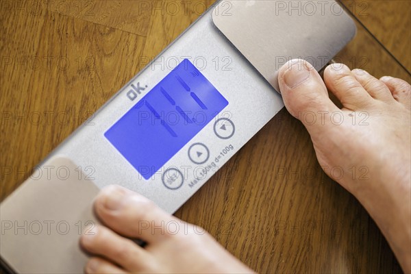 Symbolic photo on the subject of body weight. The feet of a 60-year-old person can be seen next to