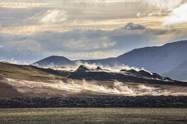 Geothermal field in front of mountain landscape, clouded, backlight, Krafla, Myvatn, North Iceland,