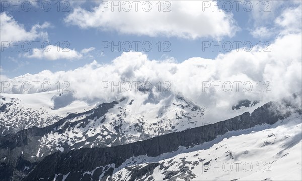 View of mountain peak Schwarzenstein with clouds and snow, mountain landscape with rocky peaks and