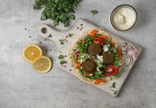 Tortilla with falafel and vegetable salad, white sauce, Arabic cuisine, top view, homemade, no