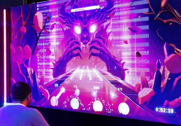 Visitors in front of a large screen with the Toxic Monster, which lives from hate on the Internet,