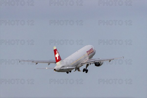 A Swiss aeroplane takes off into the sky with a clear blue background, Stuttgart