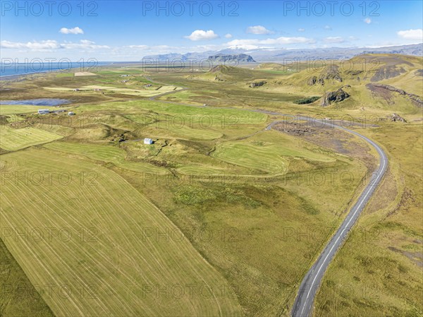 Aerial view of road leading to Cape Dyrholaey, lava formations and meadows, southern coast,