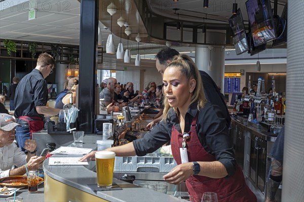 Denver, Colorado, Workers at bar dough, an airport restaurant and bar, serve travelers at Denver
