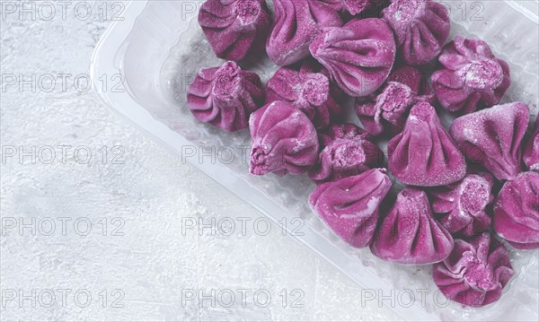 Freshly frozen beetroot khinkali, in a container, top view, no people