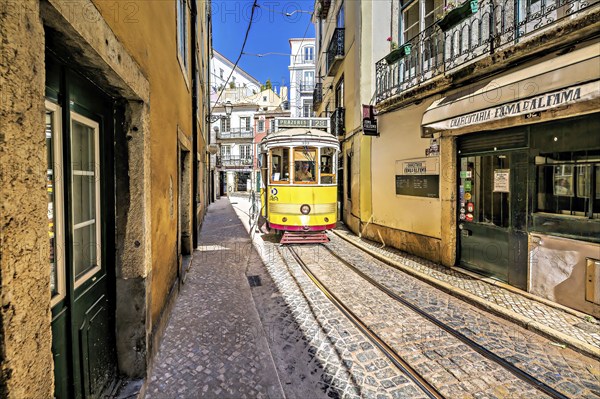 A vintage yellow tram navigates a narrow cobblestone lane in Lisbon, reflecting a sunny, vibrant