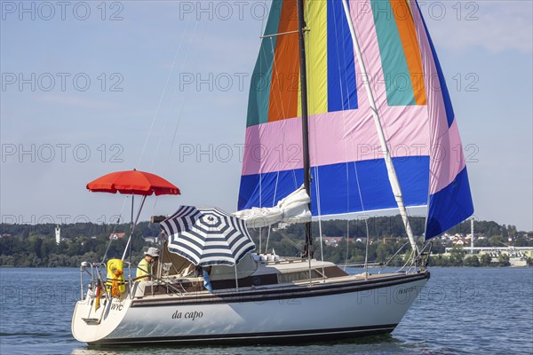 Sailing party on Lake Constance, yacht with colourful foresail and sunshades, Immenstaad,