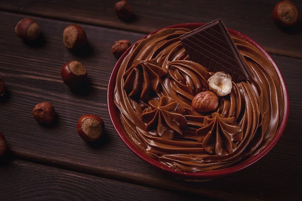 Chocolate nut paste, mousse, pasta, in a cup, on a wooden table, top view, selective focus, no