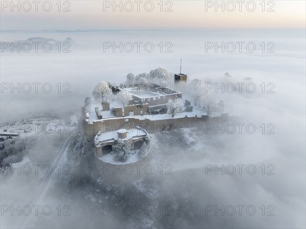 Aerial view of the Hegau volcano Hohentwiel with Germany's largest fortress ruins on a cold, foggy
