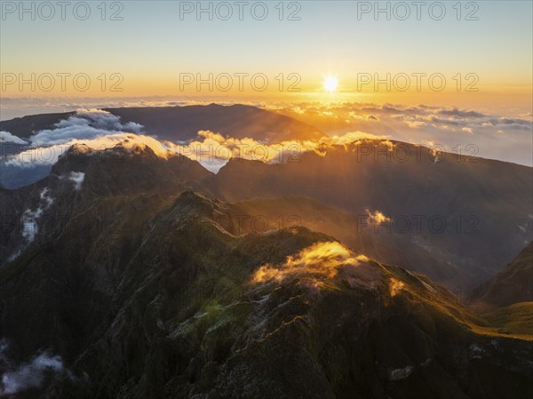 Aerial drone view of mountains over clouds near Pico Ruivo on sunset. Madeira island, Portugal,