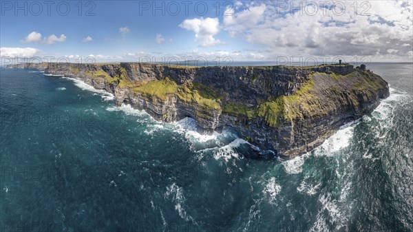 Imposing coastal cliffs with powerful sea waves under a blue sky, Cliffs of Moher