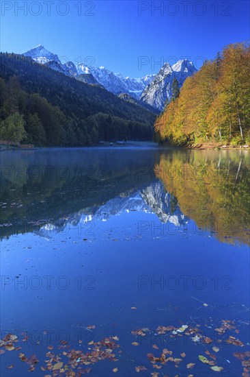 Mountains reflected in lake, fog, morning light, autumn colours, Riessersee, Waxensteine behind,