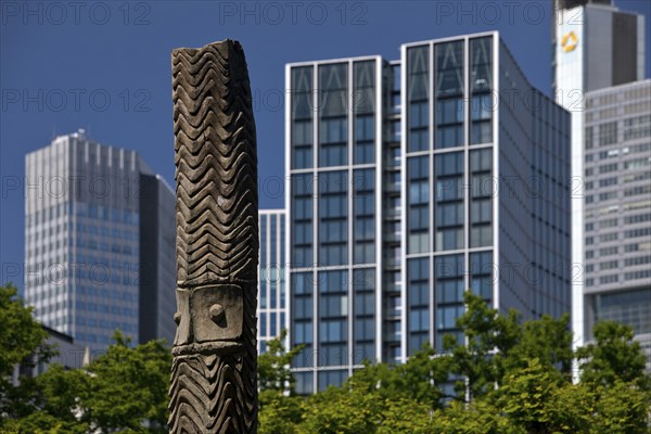 Stele made of carved wood from Papua New Guinea at the Weltkulturen Museum in front of skyscrapers,