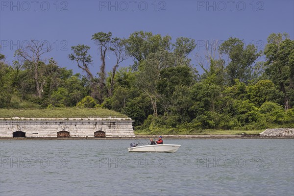 Anglers in their boat on the banks of the Giudecca Canal. Forest and a fortification in the