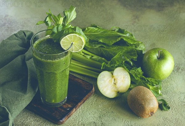 Glass, with green smoothie, celery and spinach, apple and kiwi, cucumber, with ingredients on the