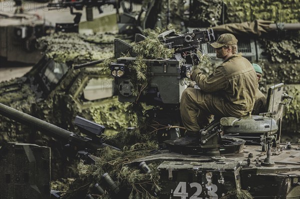 A soldier sits on a tank, taken as part of a Bundeswehr exercise with armed forces from Norway and