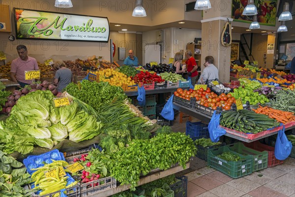 Lively vegetable market with a variety of fresh produce and people shopping, market hall, Xanthi,