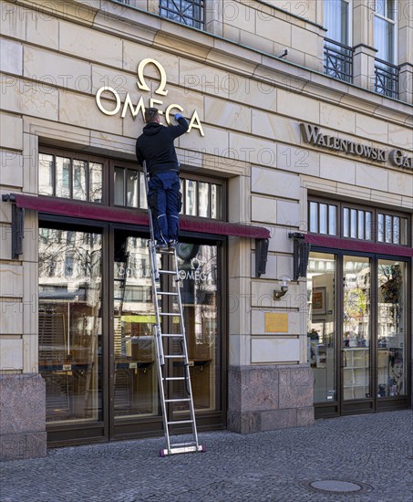Omega, craftsman cleans the company logo, Unter den Linden, Berlin, Germany, Europe