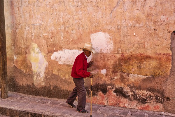San Miguel de Allende, Mexico-3 December, 2018: Old man walking down the streets of San Miguel de