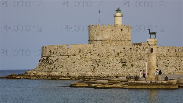 People strolling past a column near an old fortress by the sea, Fort of Saint Nikolaos, European