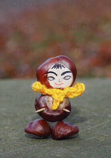 Funny chestnut figure with yellow scarf on a wall, North Rhine-Westphalia, Germany, Europe