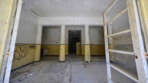 Abandoned interior with graffiti, pillars and bare walls in a desolate state, Lost Place, Former