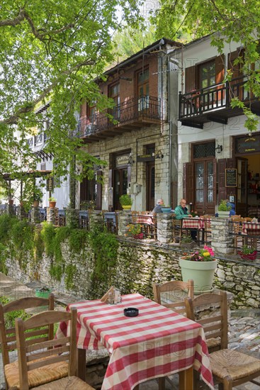Cosy village ambience with café tables on a stone wall lined with plants, Makrinitsa, Balcony of