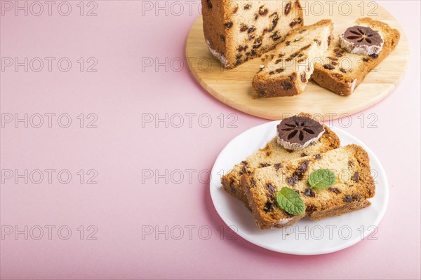 Homemade cake with raisins and dried persimmon on a pink pastel background. Side view, close up,