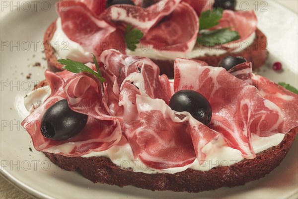 Sandwich with cream cheese, prosciutto with olives, breakfast
